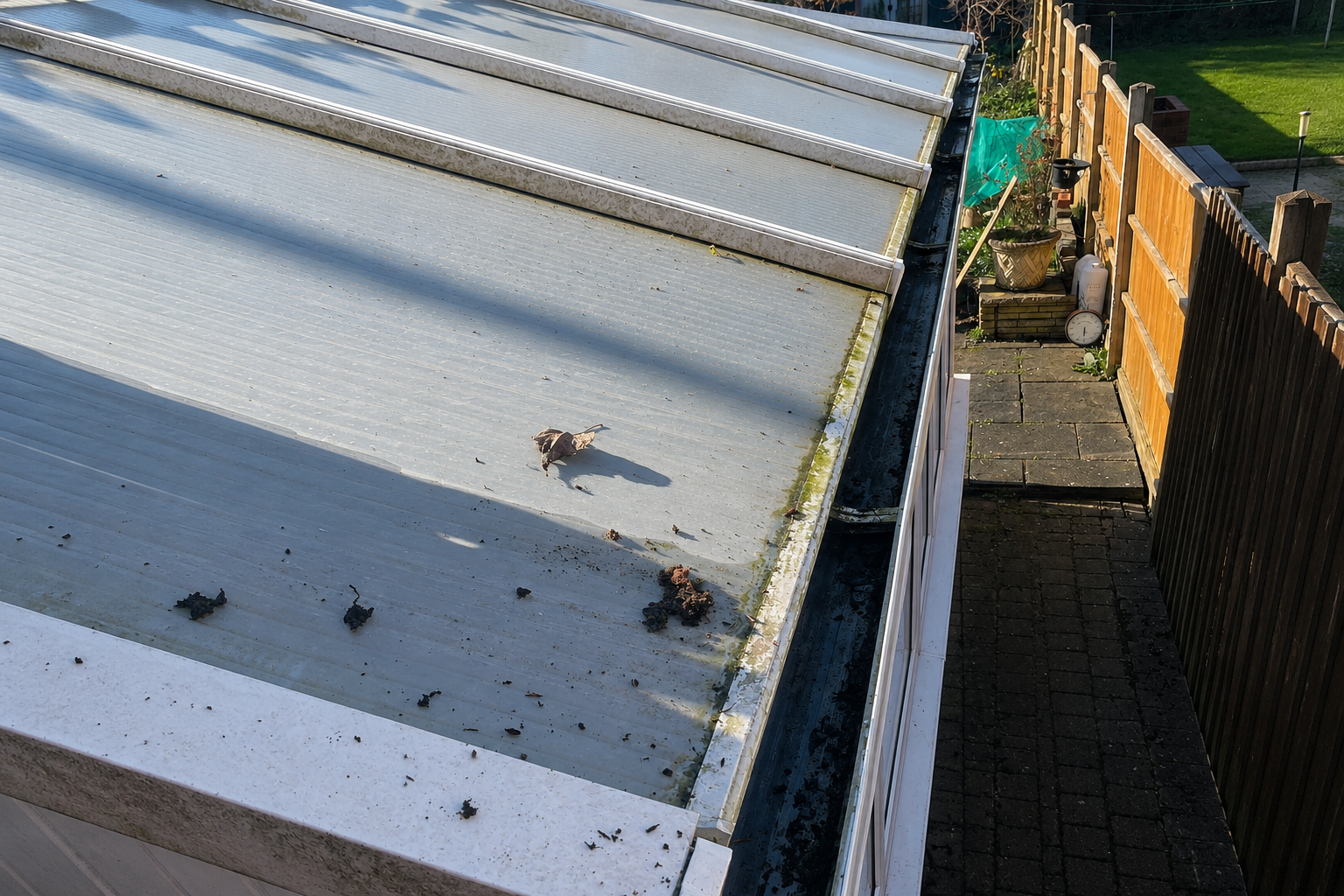 Blocked gutter with debris accumulation on Birmingham conservatory roofline — silent property damage indicator